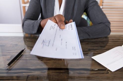 employer handing employee a paycheck
